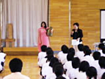 ネパール出身のボランティアから説明を聴く生徒たちと全員の「ふるさと」の合唱(右)