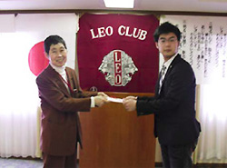 関根会長(右)から目録贈呈される向井田常務理事