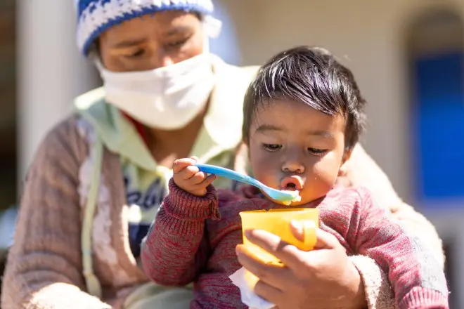 ご飯をスプーンで食べる子ども